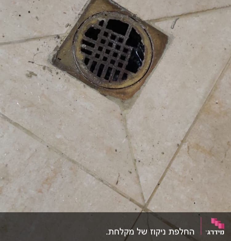 ניקוז מרובע ברצפה עם לכלוך מסביב